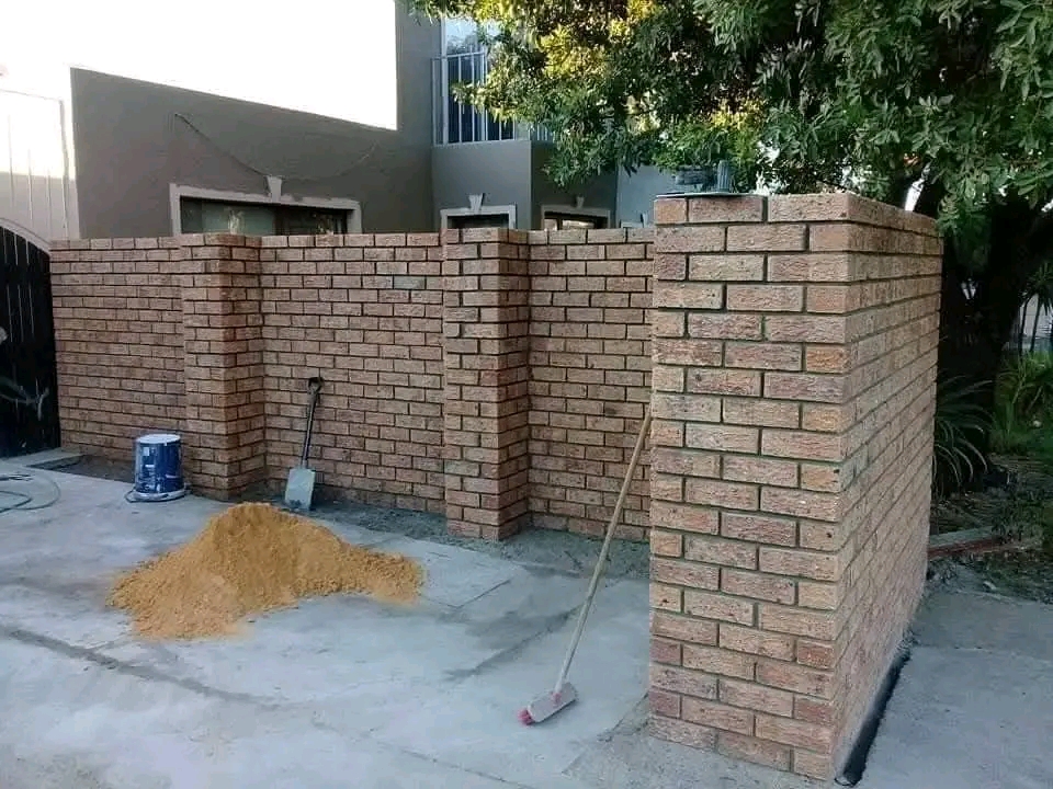 Newly built brick boundary wall and pillars